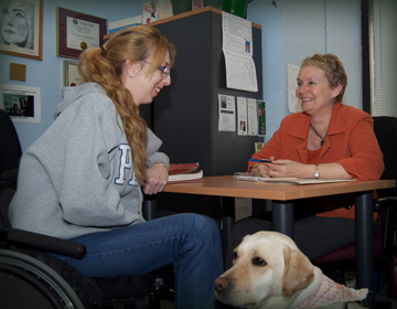 Student in wheelchair meeting with college counsellor.